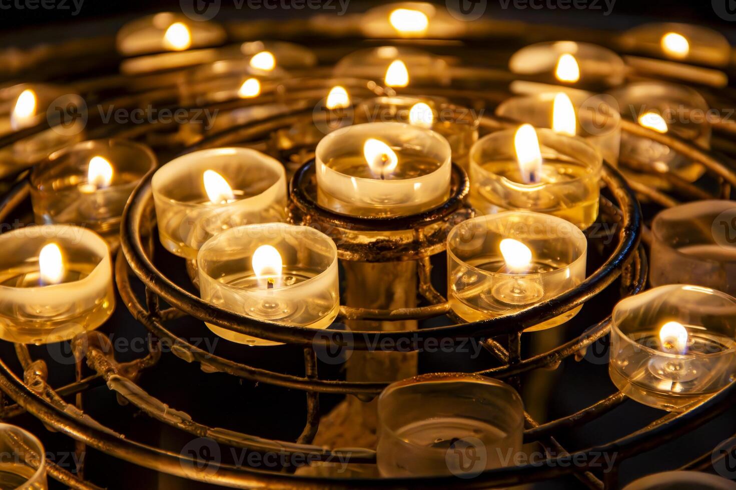 Lit Candles on Circular Metal Stand in a Darkened Room photo