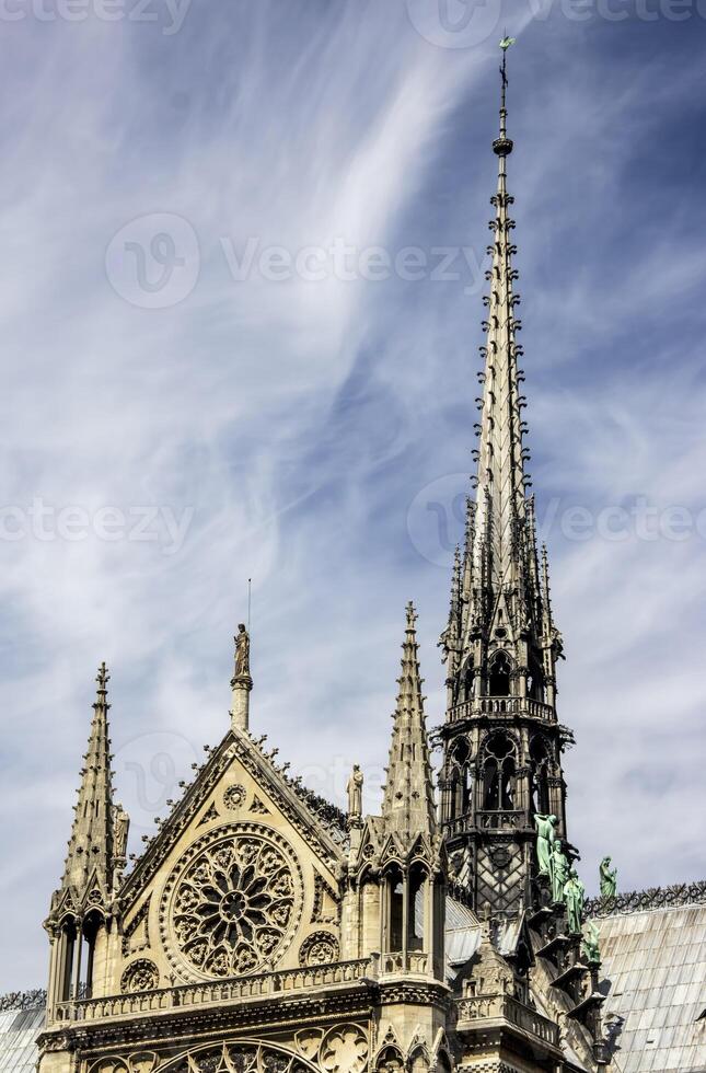 Detailed View of Notre Dame Cathedral Spire and Rose Window in Paris photo