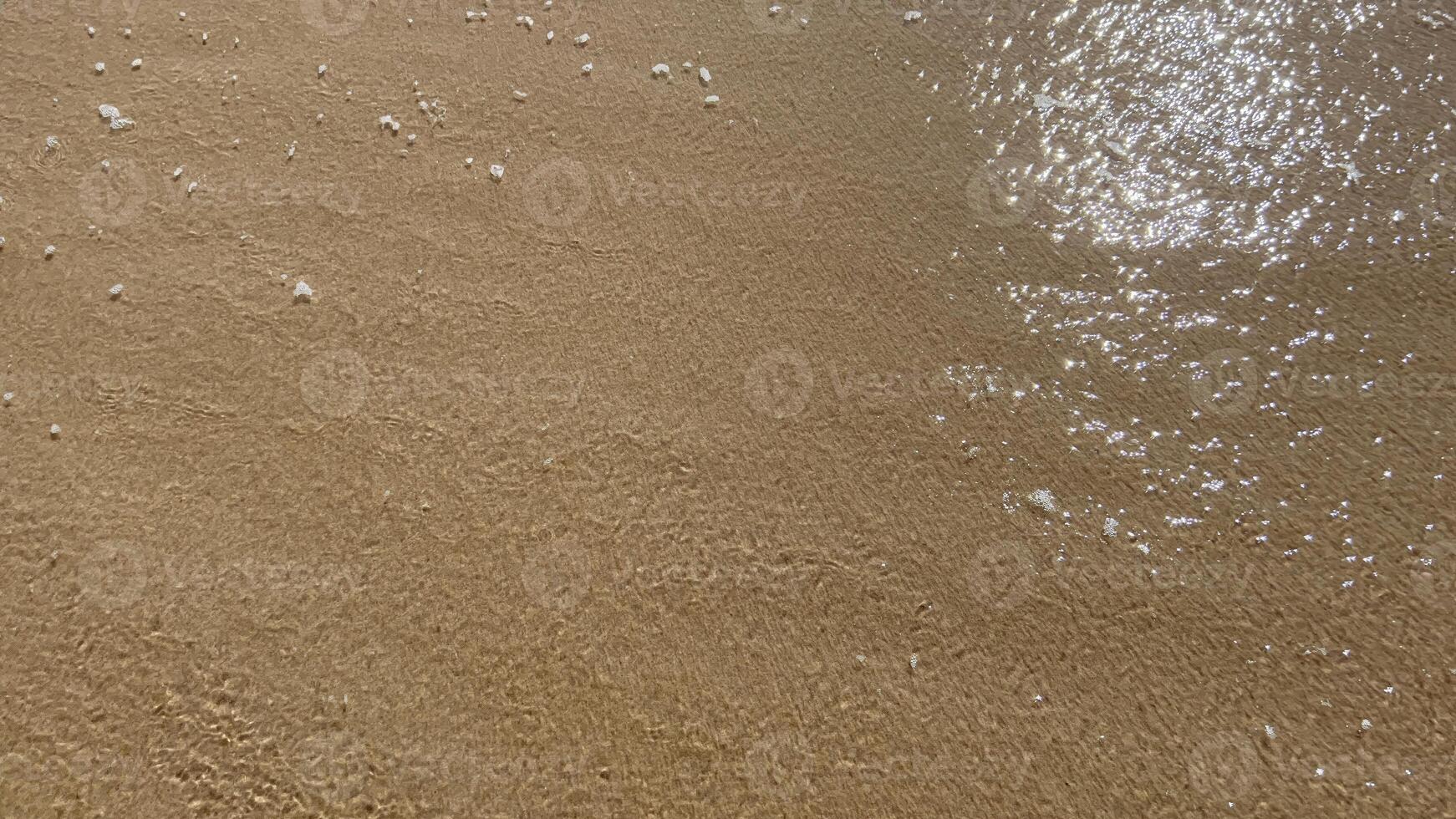 Sandy Beach With Gentle Waves and Glimmering Sunlight on the Magdalen Islands, Quebec, Canada photo