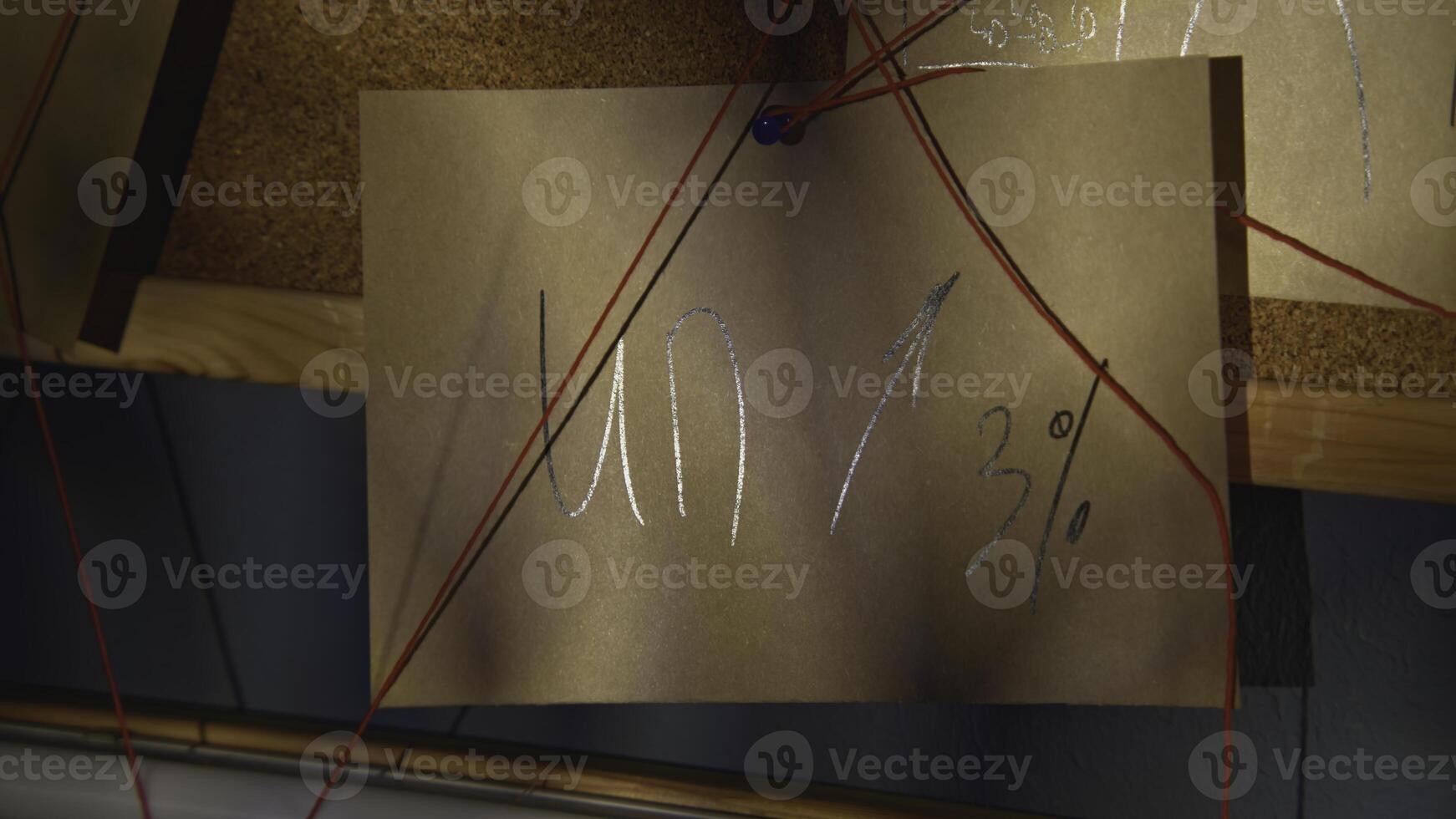 Notes with red thread. Stock footage. Close-up of mysterious notes connected by red thread. Symbols and puzzles on mysterious board with threads photo