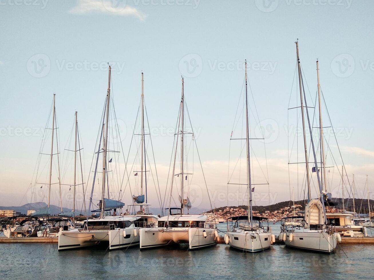 Sailing yachts stand in a row in the marina at sunset photo