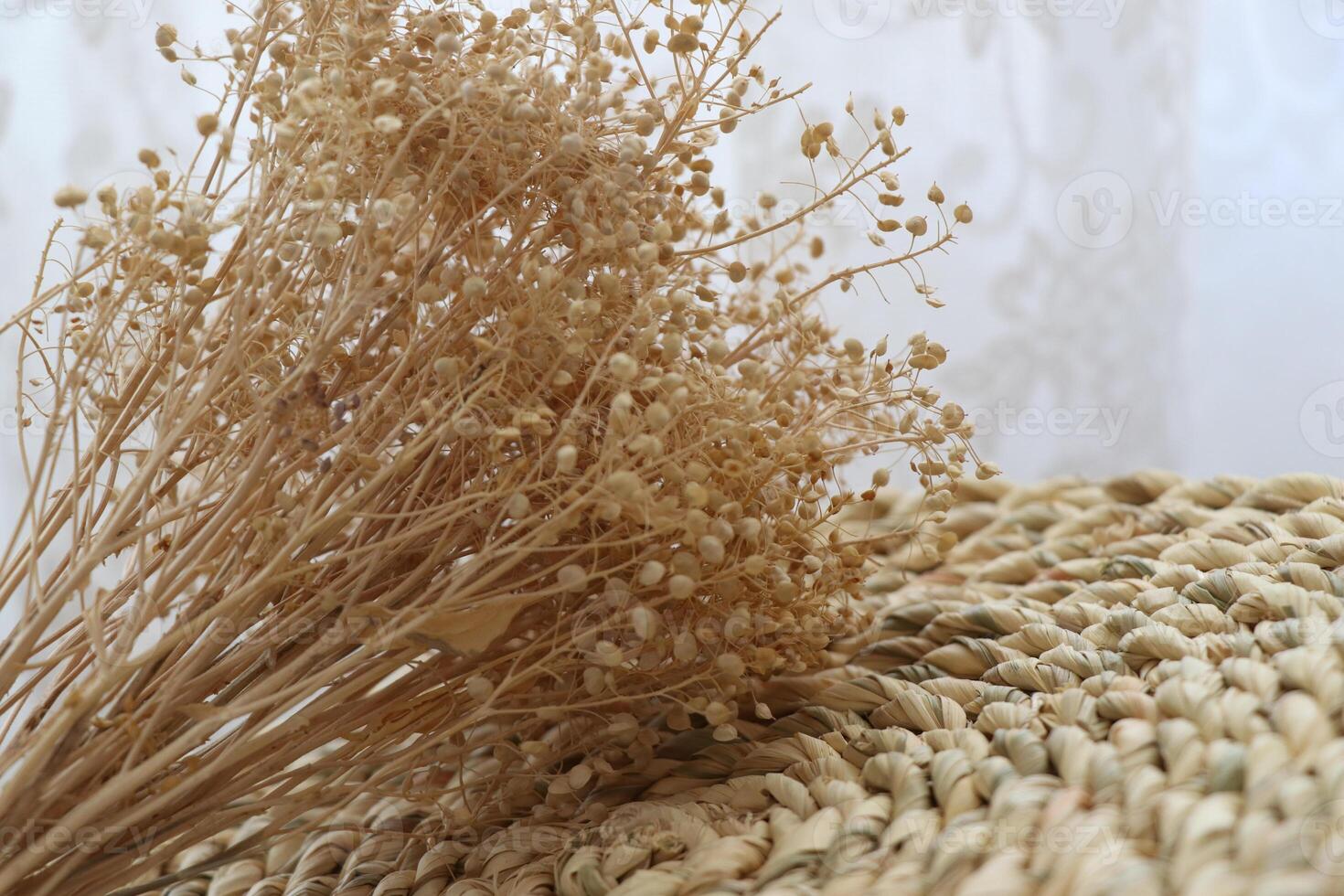 Dry flax plant and traditional painted vase on a wicker basket - Minimal decorative items photo