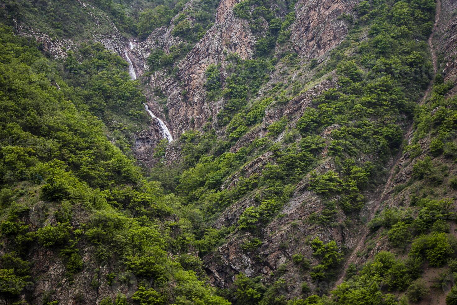 A beautiful waterfall in the heart of the mountain photo