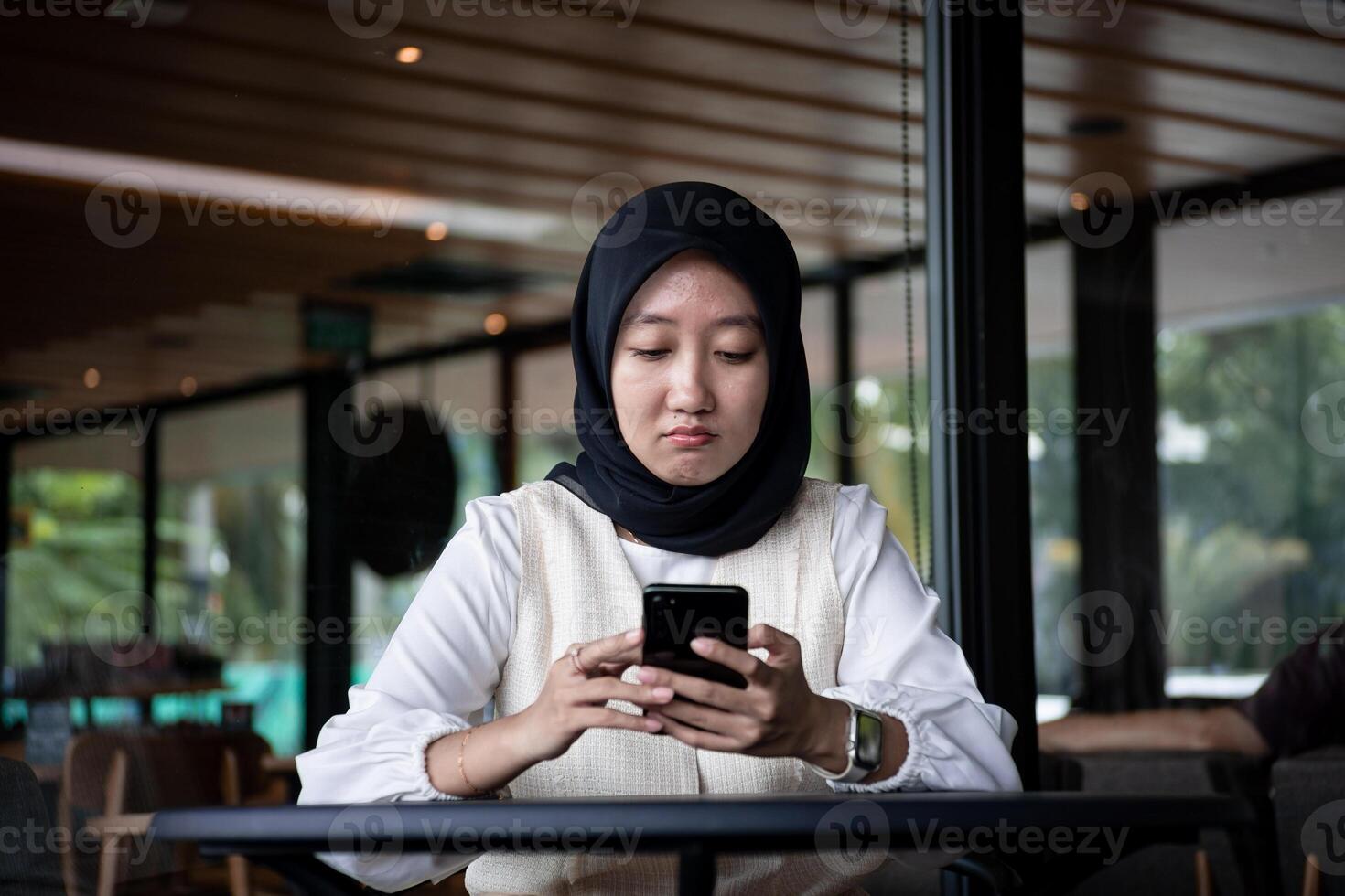 portrait of beautiful Asian woman in hijab. receive a message with a sad facial expression photo