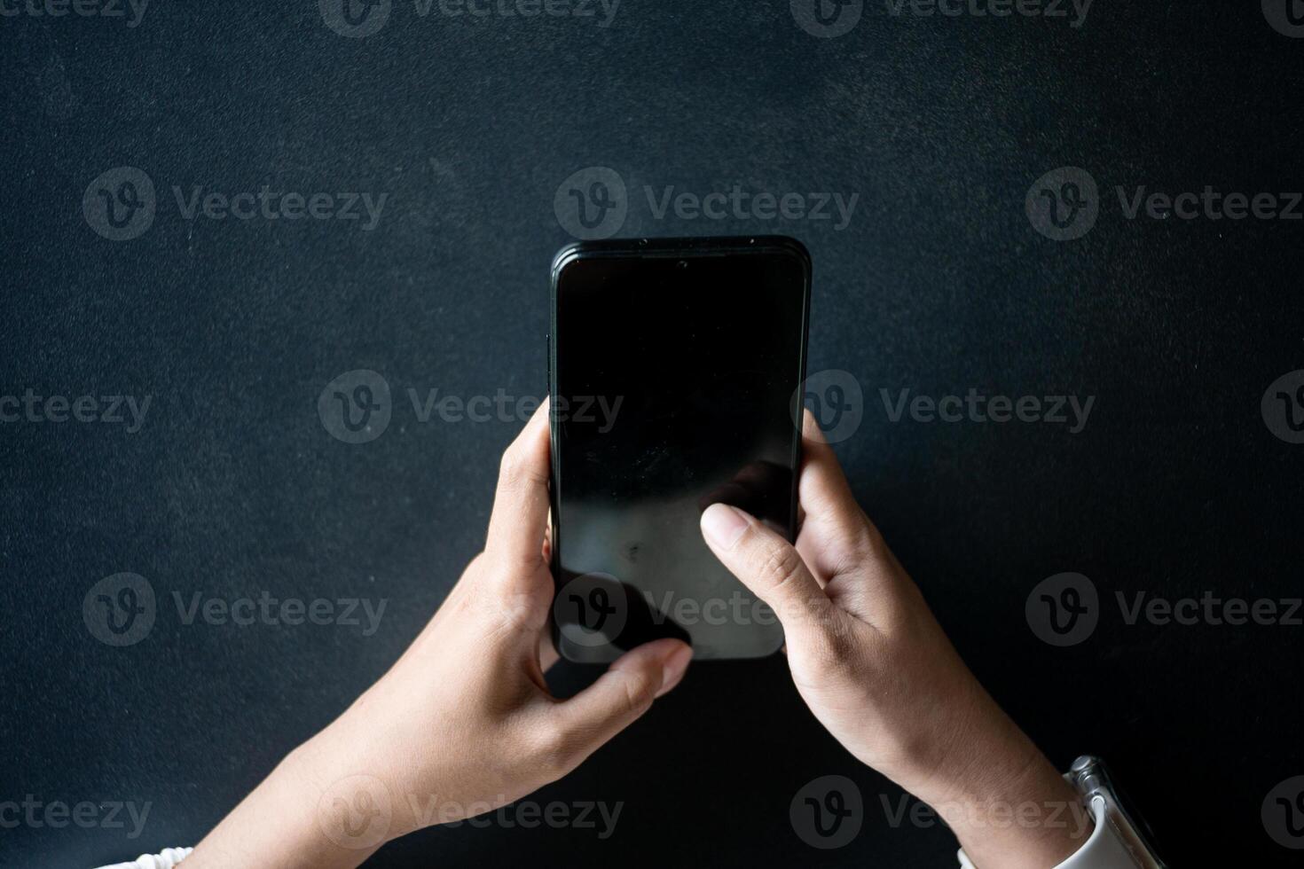 Close up of woman hand using modern smart phone while working in office with computer. and typing a text message on his cell phone. photo