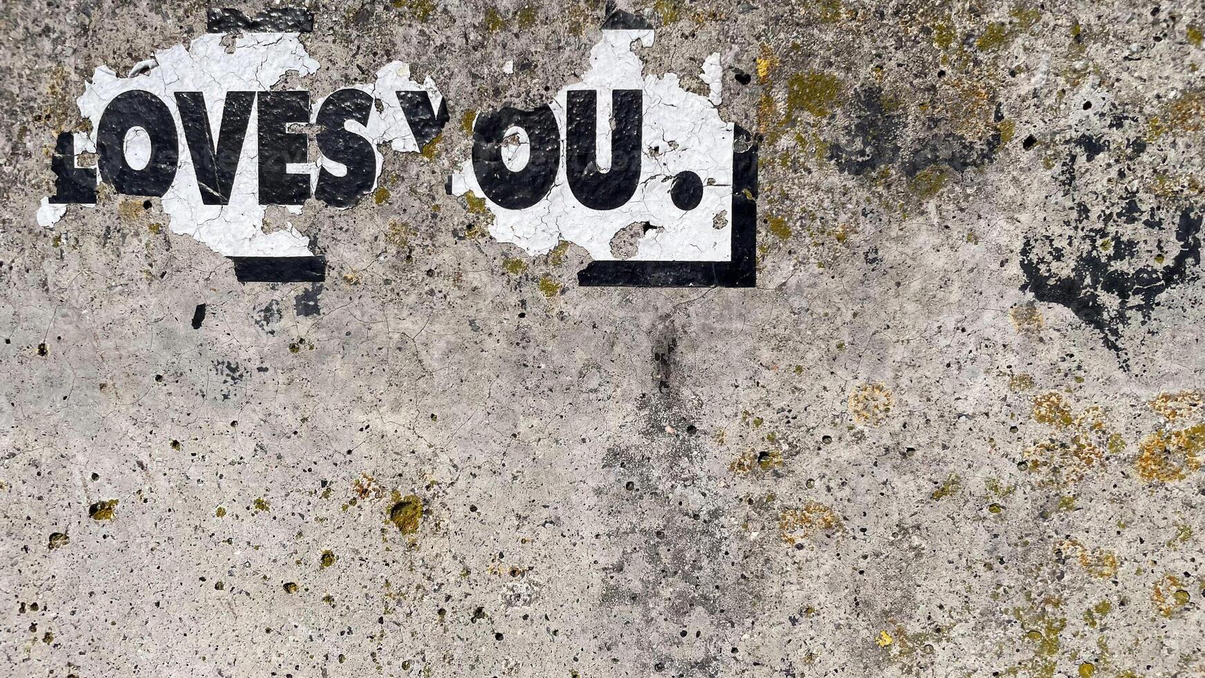 Torn paper on wall with 'LOVE YOU' message, expressing affection and emotion. Perfect for romantic concepts. photo