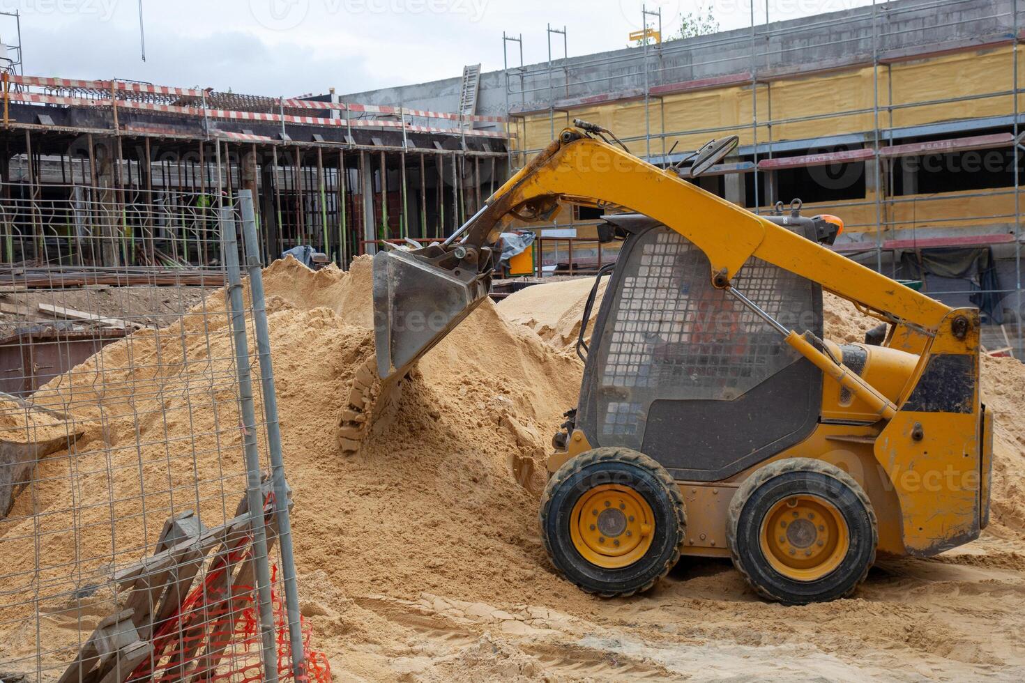 Mini excavator at work on building renovation site. photo