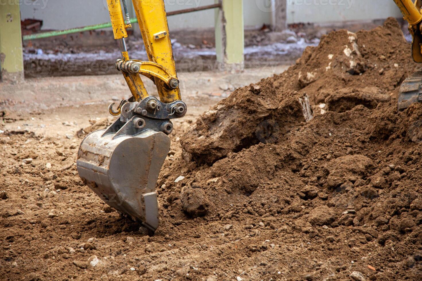 Close-up view of an excavator claw scoop digging into earth, capturing the power and precision of heavy machinery in action. photo