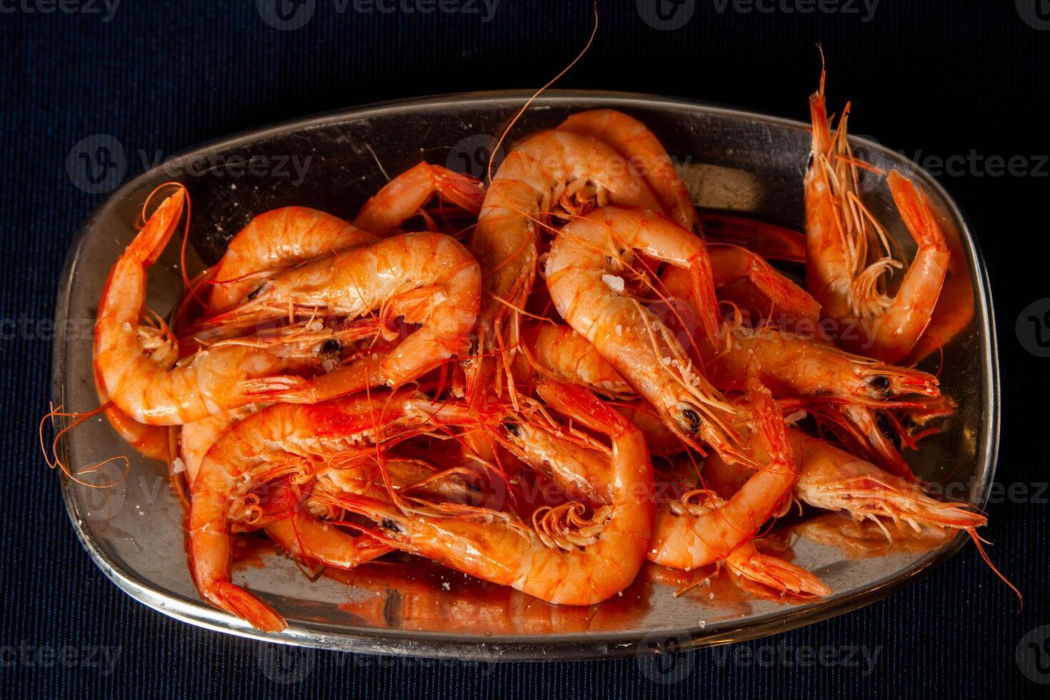 Delicious cooked shrimp served on a platter, perfect for seafood enthusiasts. Vibrant colors and enticing presentation. photo