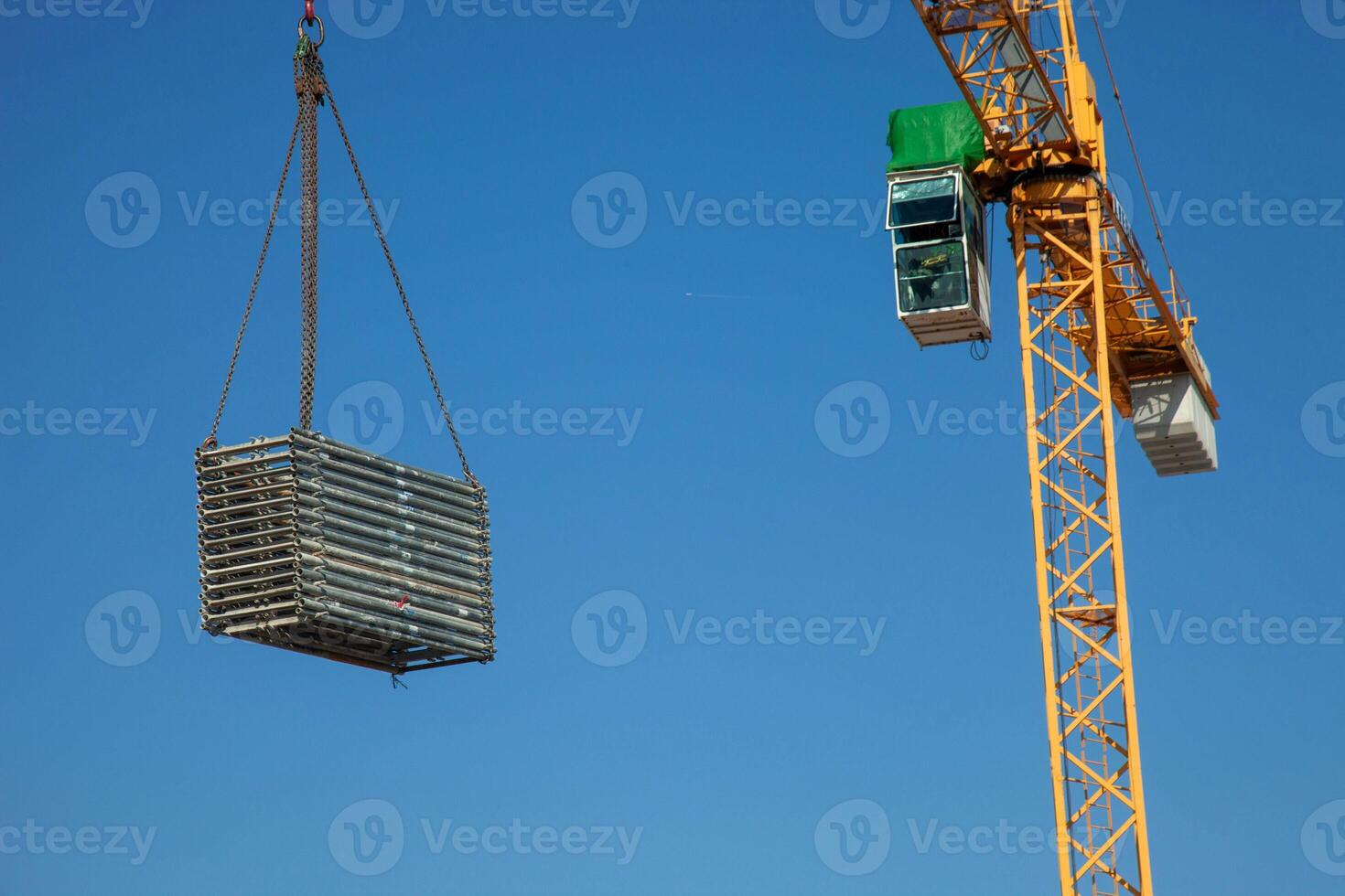 A construction crane hoists materials across a busy worksite, showcasing the dynamic energy and precision involved in modern building projects. photo