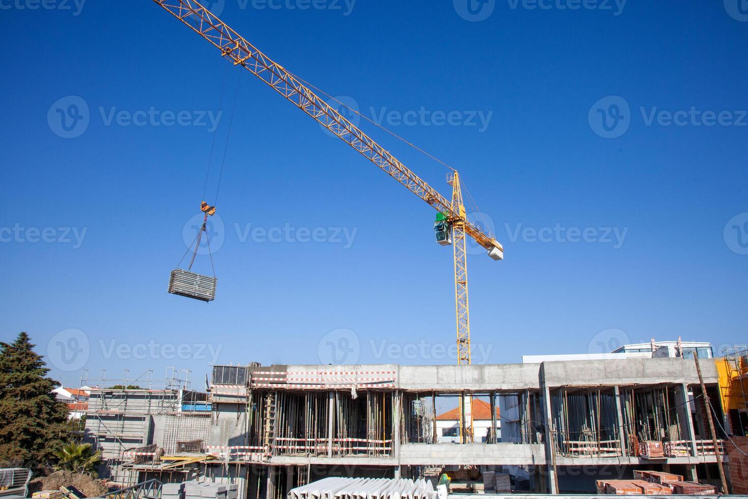 A construction crane hoists materials across a busy worksite, showcasing the dynamic energy and precision involved in modern building projects. photo