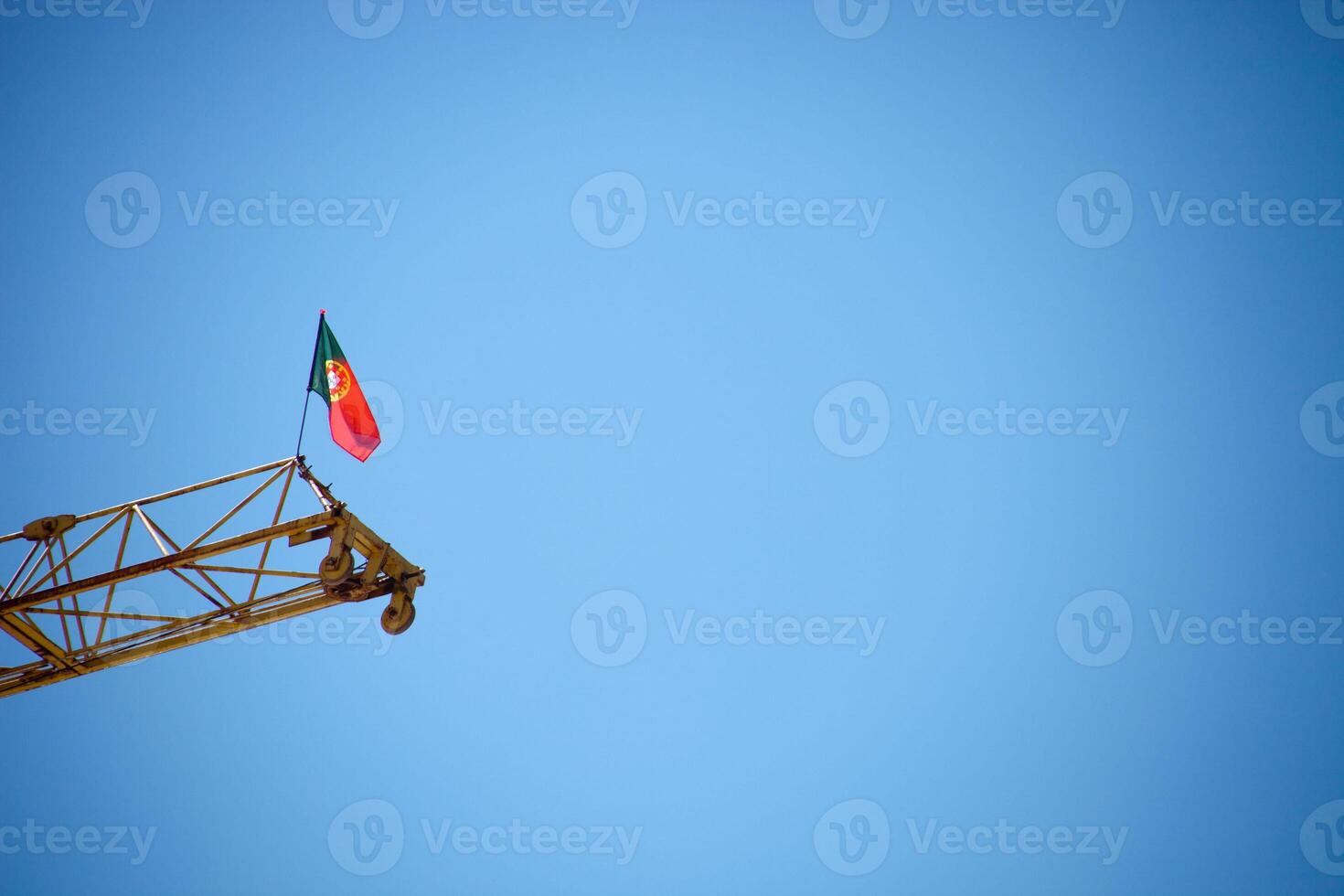 Portuguese flag waving atop a crane, symbolizing progress and national pride. photo