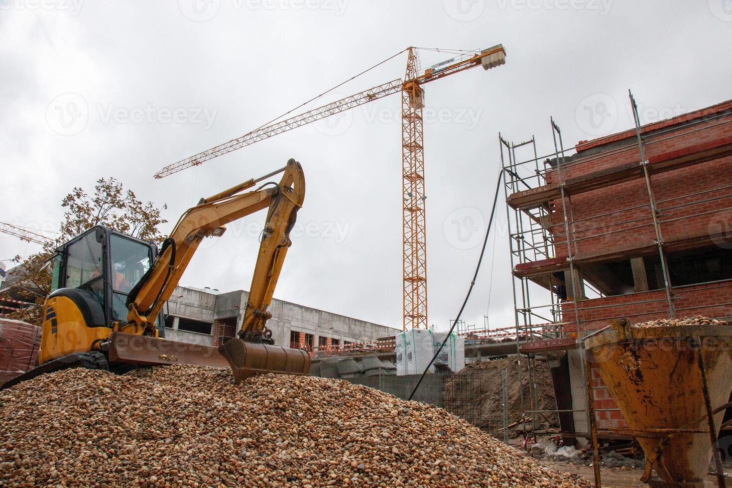 Construction site featuring a crane and a backhoe, undergoing renovation. Dynamic scene of urban development in progress. photo