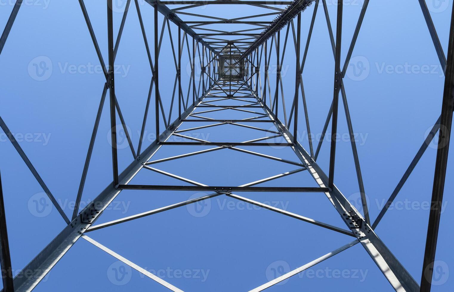 Electric antenna and communication transmitter tower in a northern european landscape against a blue sky photo