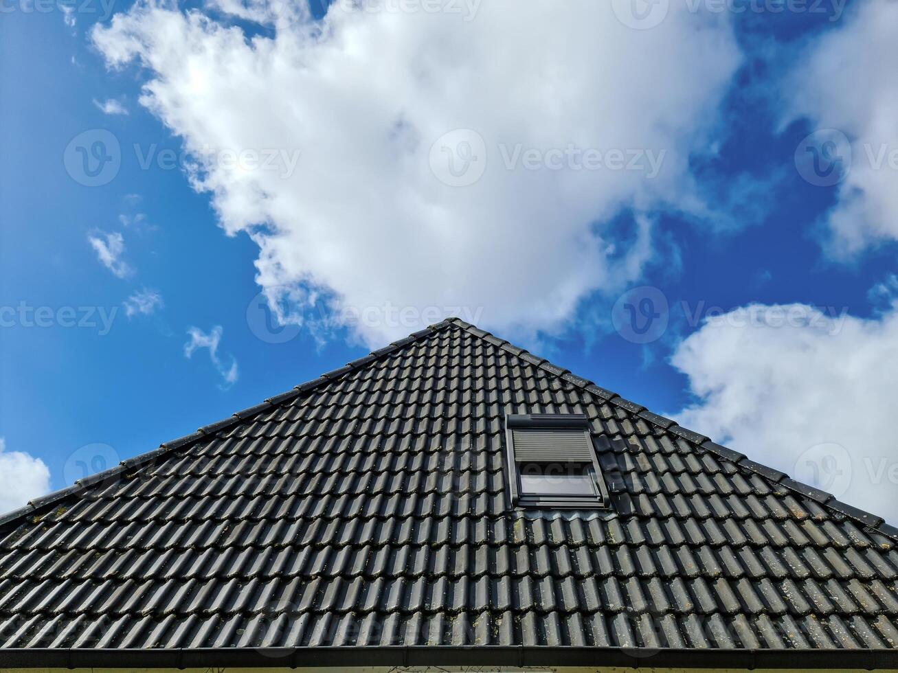 Open roof window in velux style with black roof tiles. photo