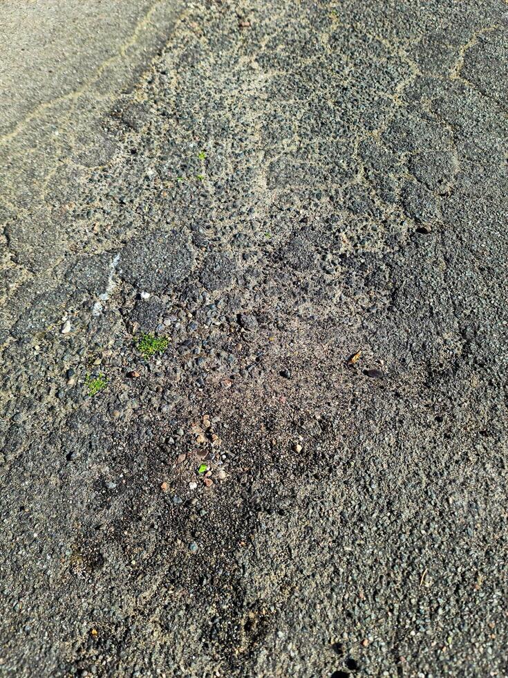 View of road asphalt with many cracks and potholes in urgent need of repair. photo