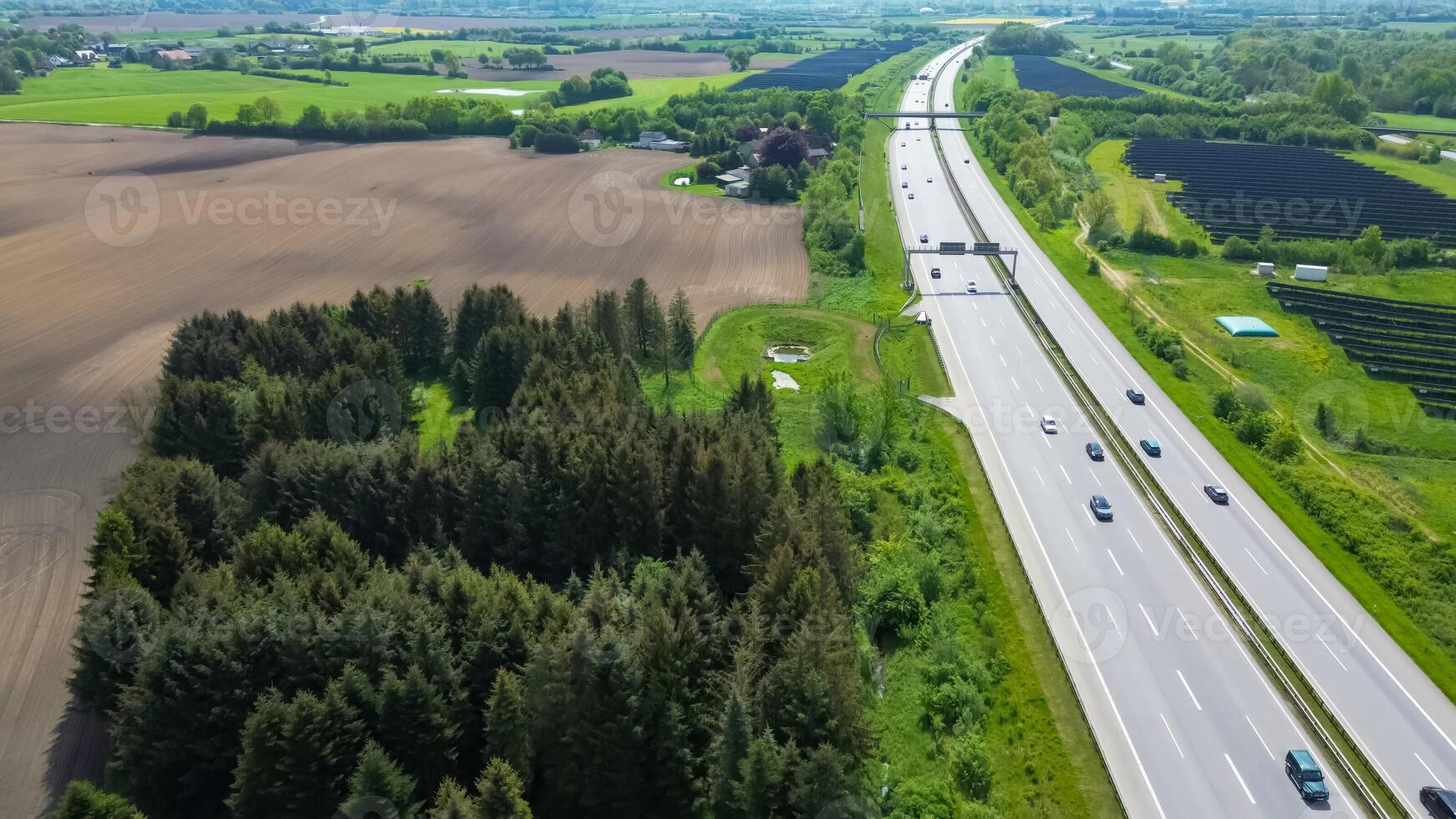 Drone view of a highway in Germany with a lot of traffic and many green fields around it. photo