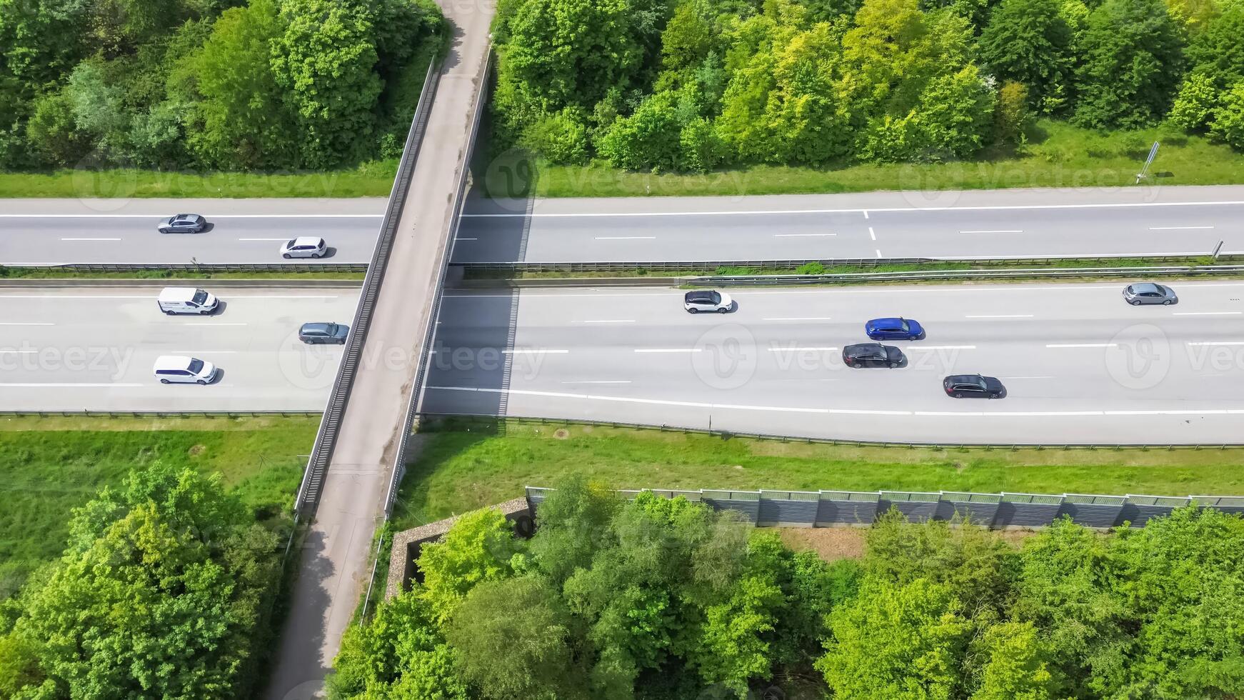 Drone view of a highway in Germany with a lot of traffic and many green fields around it. photo