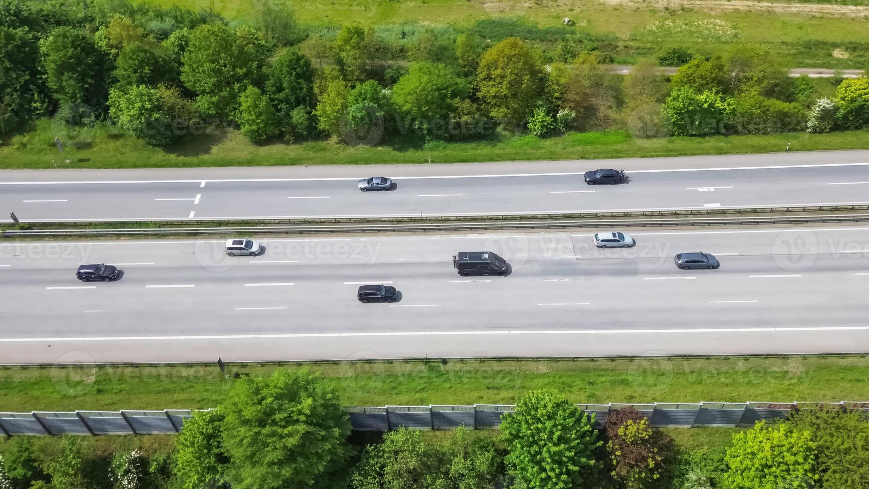 Drone view of a highway in Germany with a lot of traffic and many green fields around it. photo