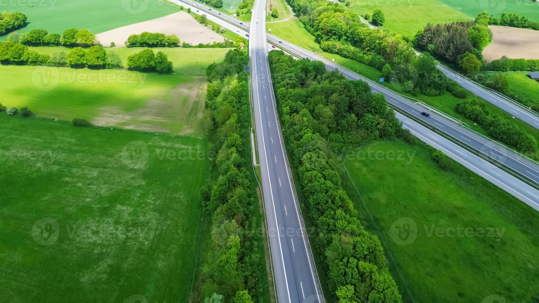 Drone view of a highway in Germany with a lot of traffic and many green fields around it. photo