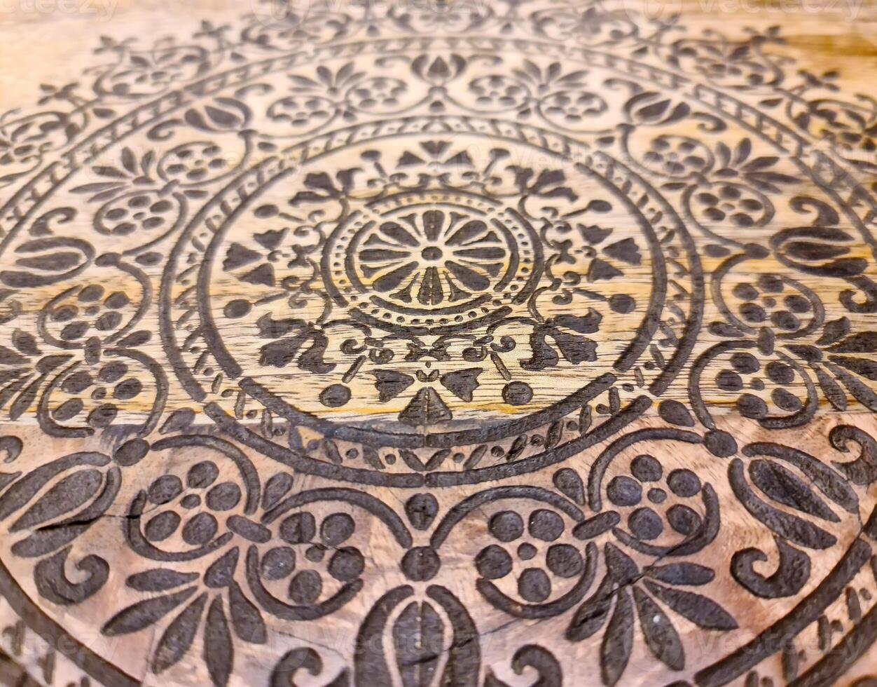 An intricate oriental pattern on a beautiful wooden surface. photo