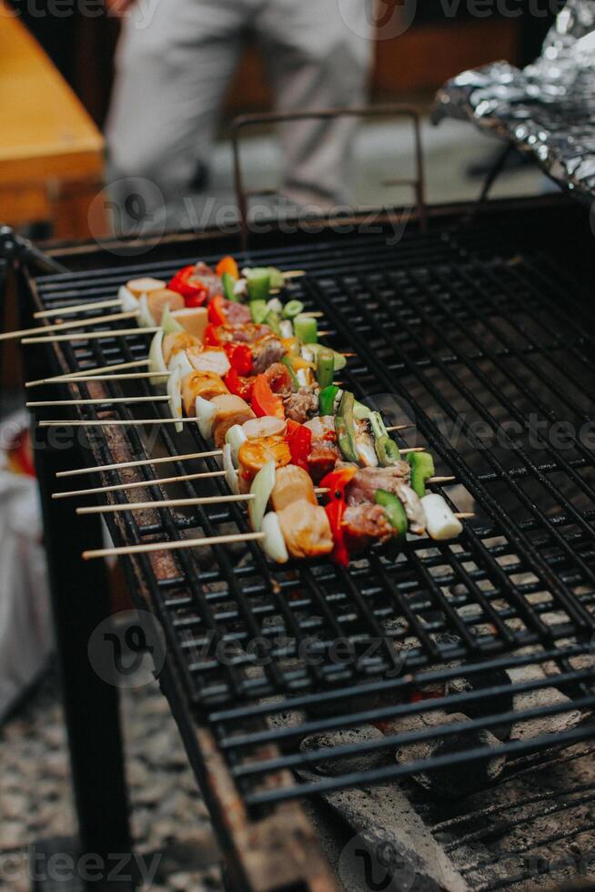 Juicy slices of meat with sauce and vegetables are cooked over an open fire. Snacks are cooked on a metal grill and ready to be served photo