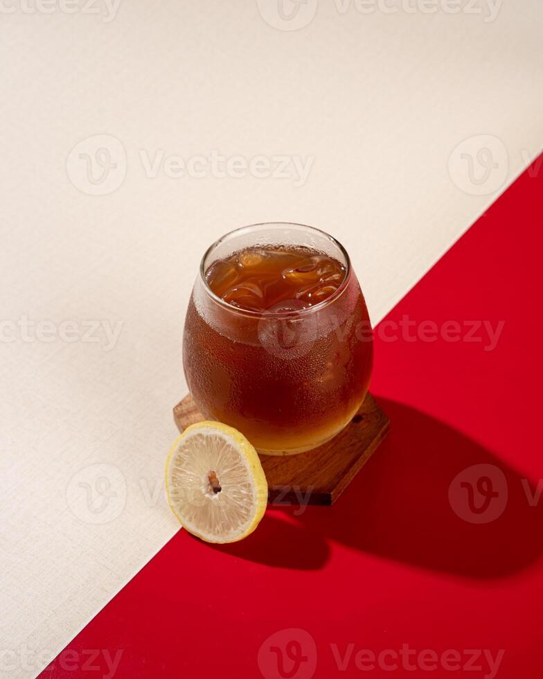 ced lemon tea is a tea drink served cold with ice cubes and lemon. photo