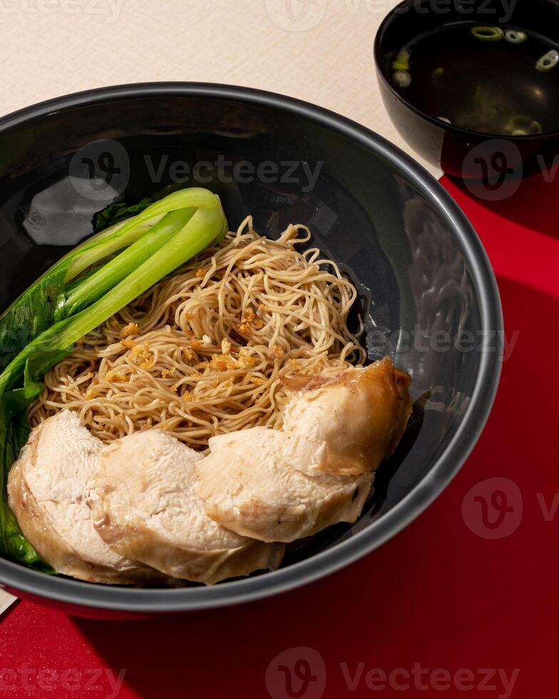 Vermicelli soup served with vegetables and pieces of chicken photo