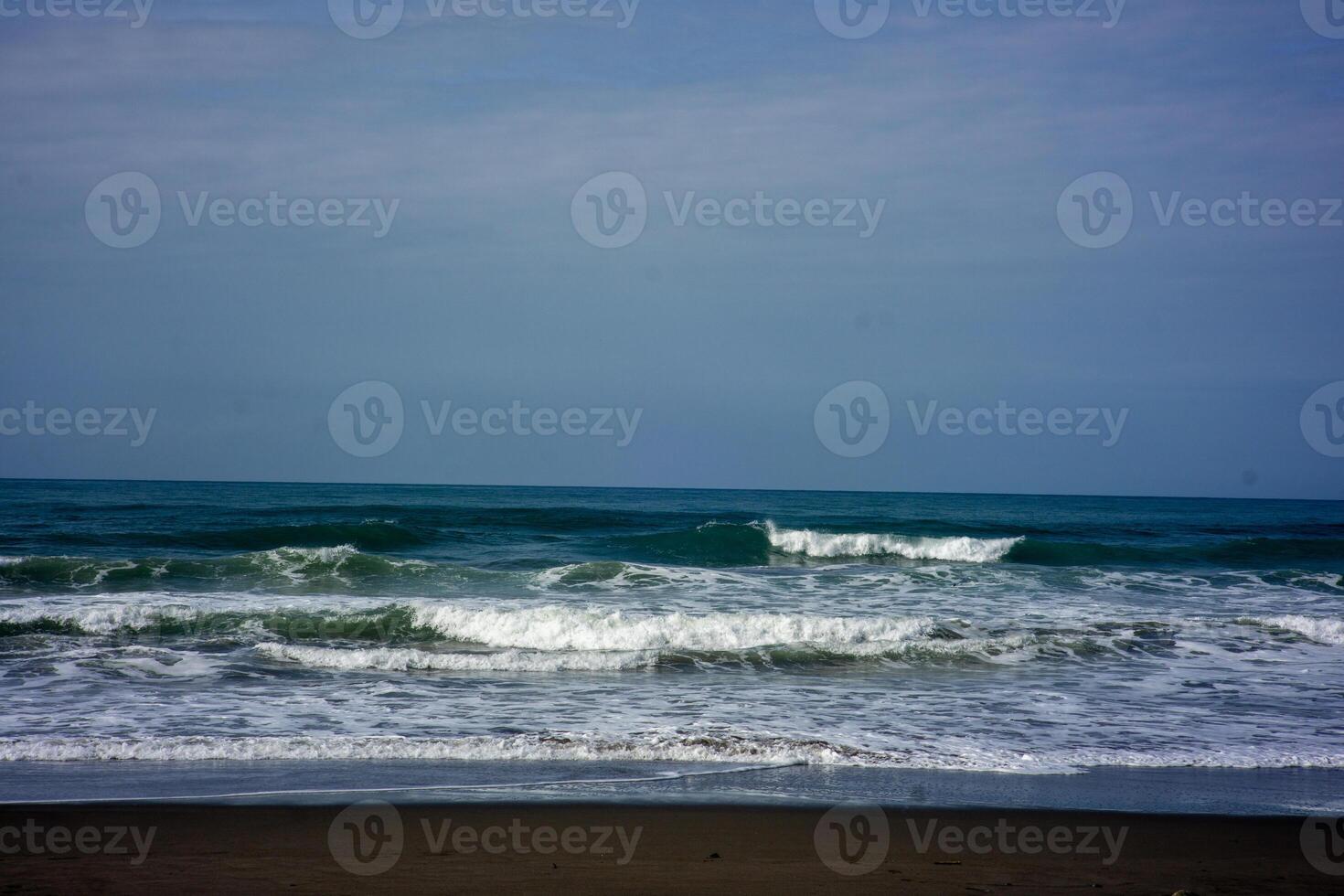 powerful foamy sea waves rolling and splashing over water surface against cloudy blue sky photo