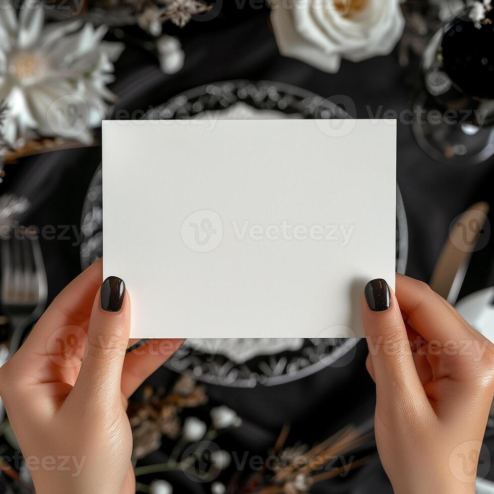 Black and white photo of a blank note being held by a woman with black nail polish.