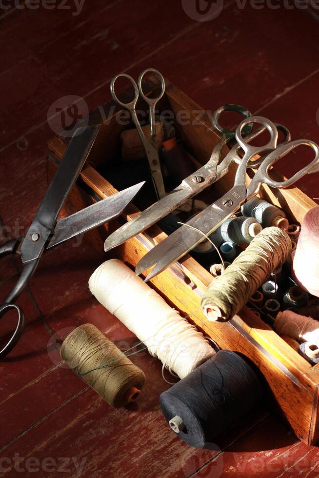 Knitting box with many thread spools and vintage scissors photo