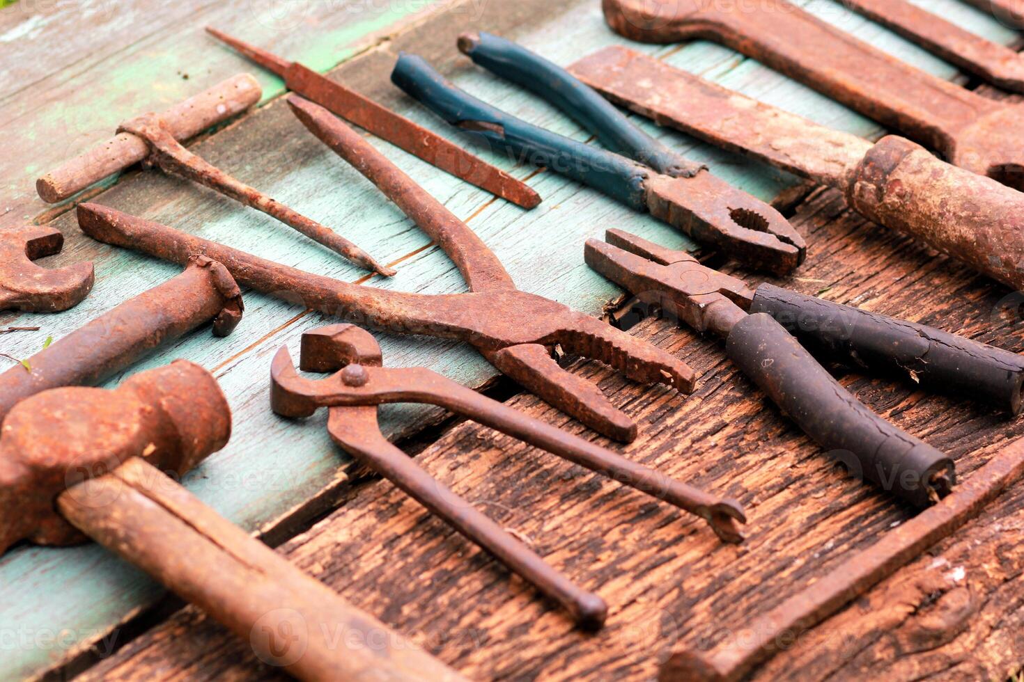 Scattered rusty tools put on wood planks photo