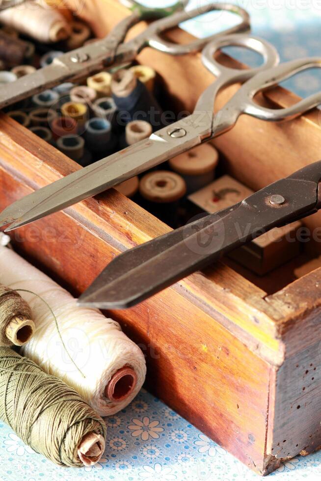 Knitting box with many thread spools and vintage scissors photo