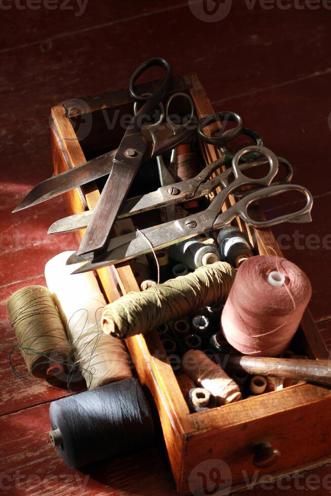 Knitting box with many thread spools and vintage scissors photo