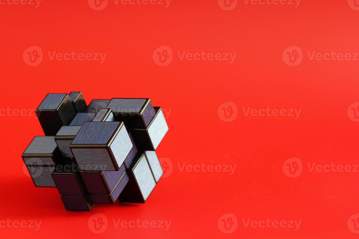 Closeup of geometric shape puzzle over red background with negative space. Science and technology concept photo