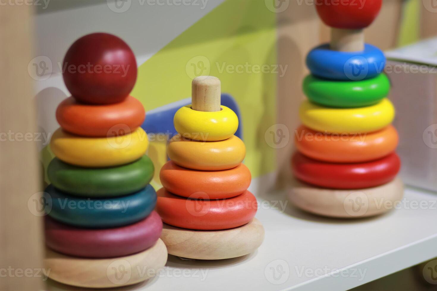 Bright colorful wooden children toy pyramids on a shelf in the shop. Toy shopping photo