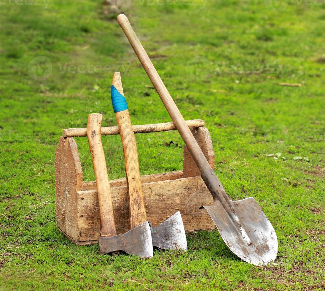 Rusty old wooden tools and instruments on the grass photo