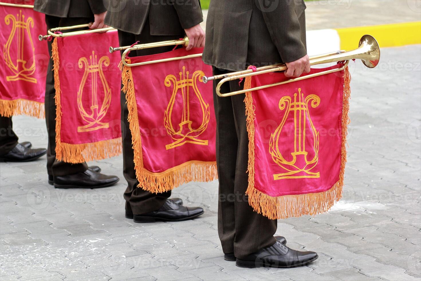 Parade of military orchestra holding musical instrument trumpet with red flag and golden lyre on it photo