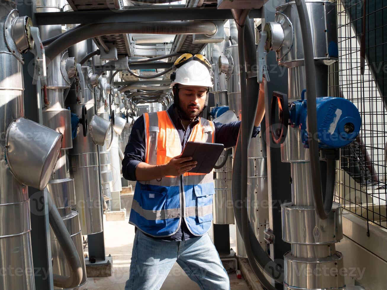 male man young adult safety helmet white hardhat look watch see information document metal pipeline water technician technology examing maintenance factory steel facility check service tool repair photo