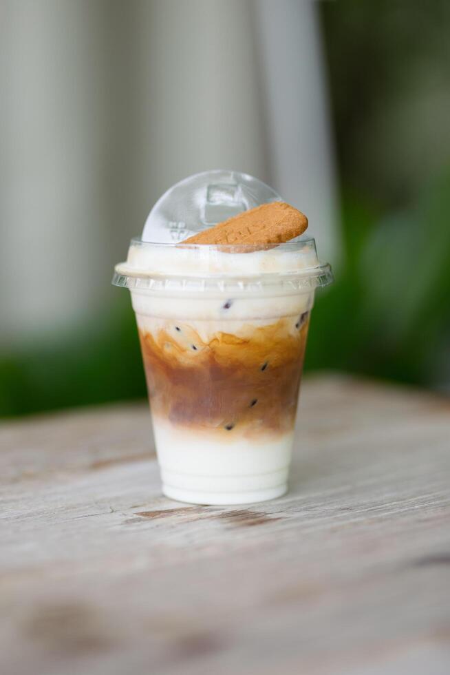 A chilled latte artfully layered, crowned with a biscuit. photo