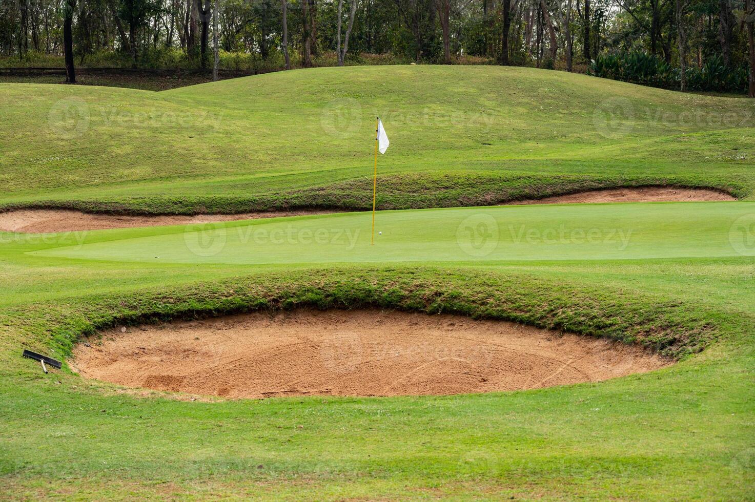 Scenery view of bunker in golf course. A bunker is positioned in the golf hole to guard the desired position in the landing area or green. photo