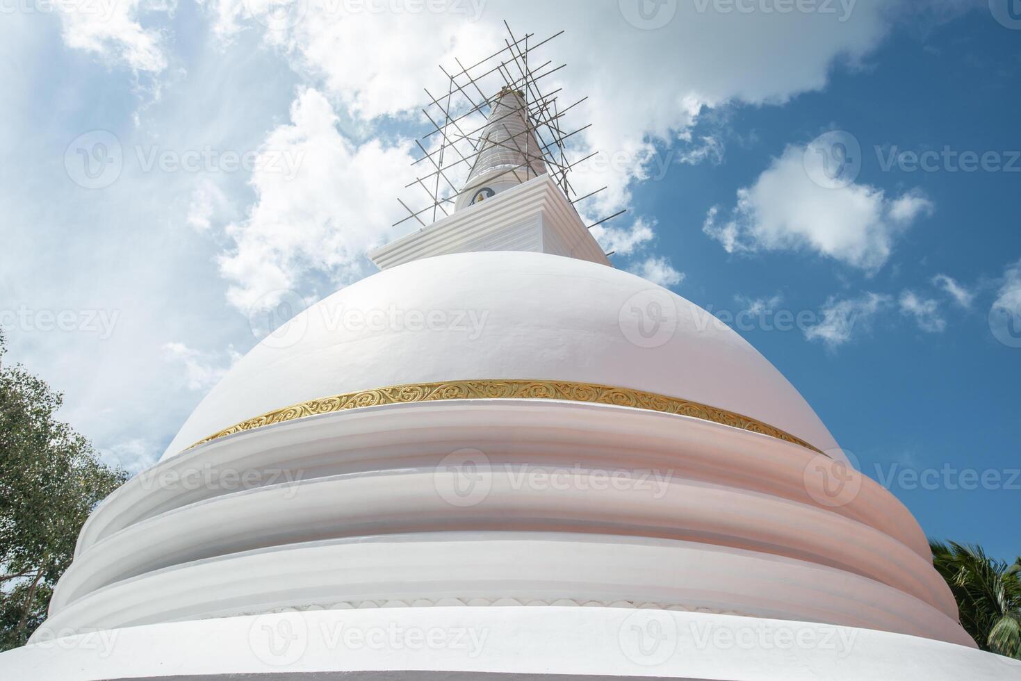 The large white stupa in Sri Maha Bodhi Viharaya temple in Kandy city, Sri Lanka. Stupa is a ceremonial burial mound used for the veneration of Buddhist saints and relics. photo