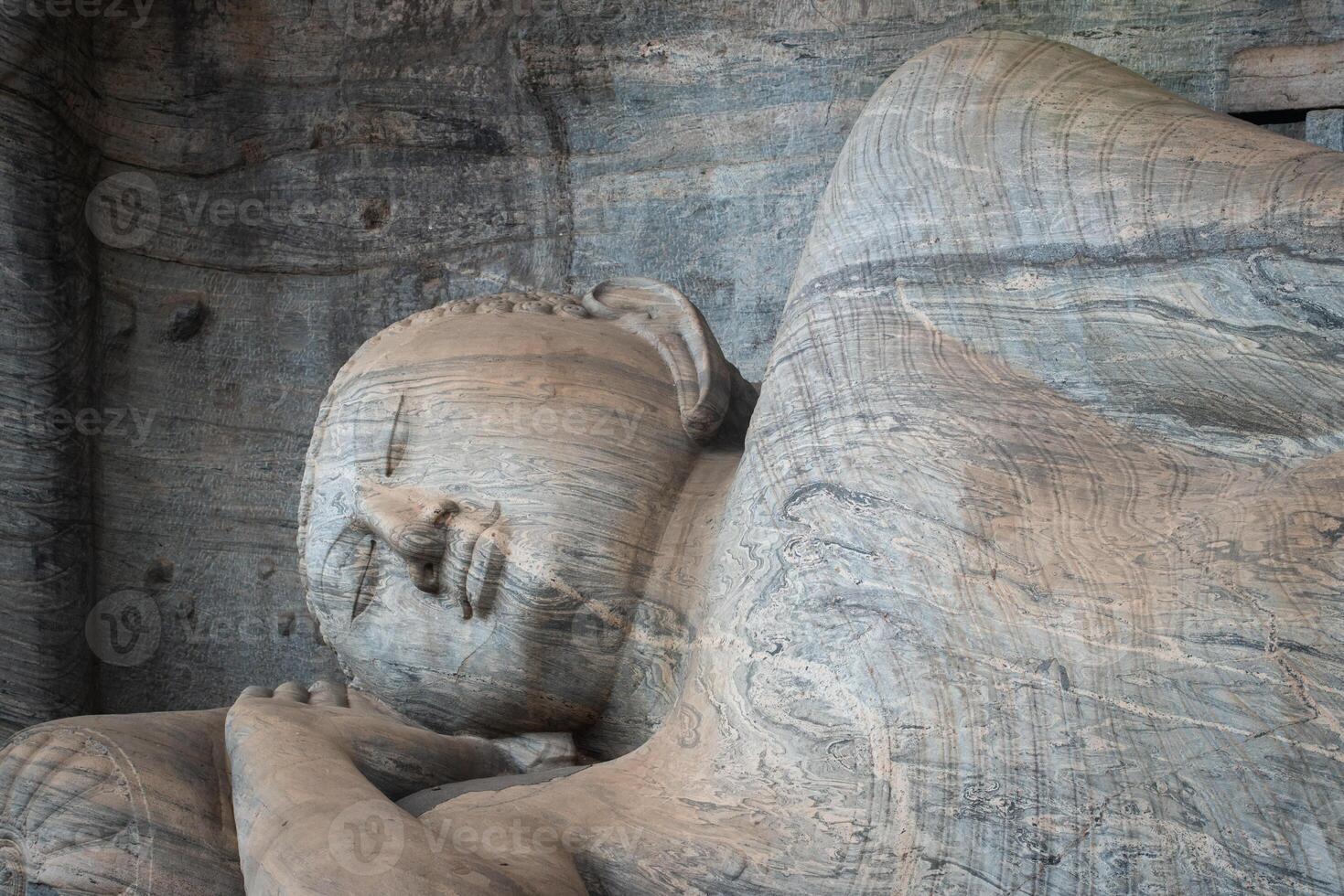 Beautiful reclining Buddha is 14 m long, picturing Buddha entering Nirvana at Gal Vihara in ancient city of Polonnaruwa, Sri Lanka. photo