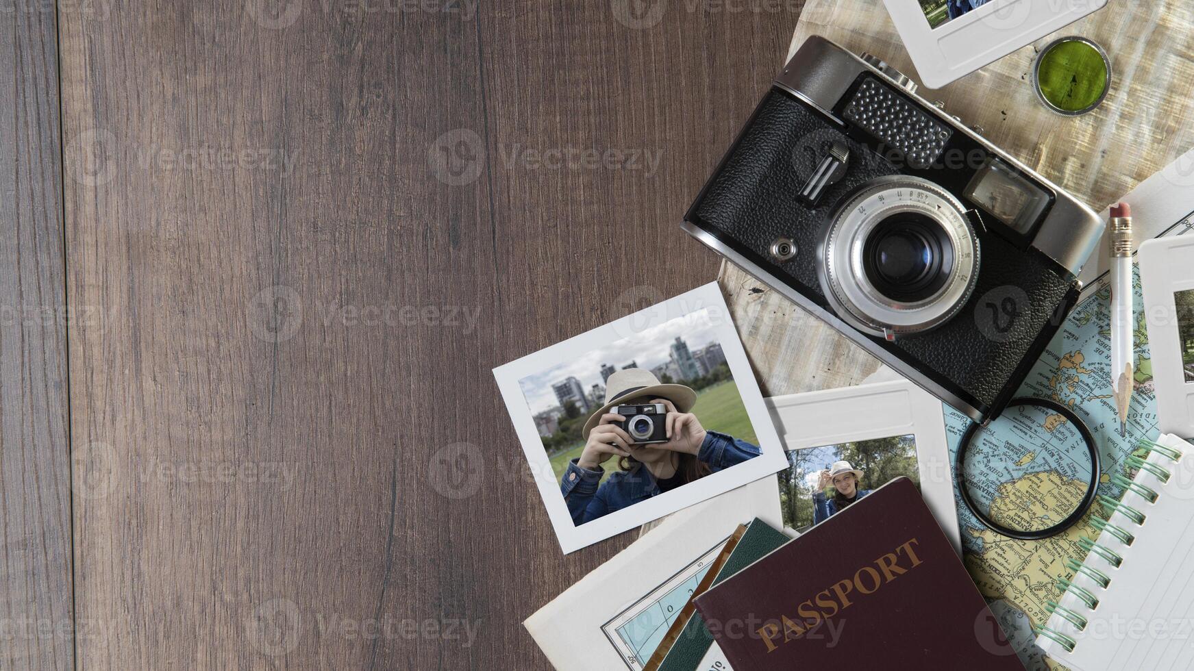 Photographs of woman taking photos, passports, old photo camera, map and notebook on a dark wooden table