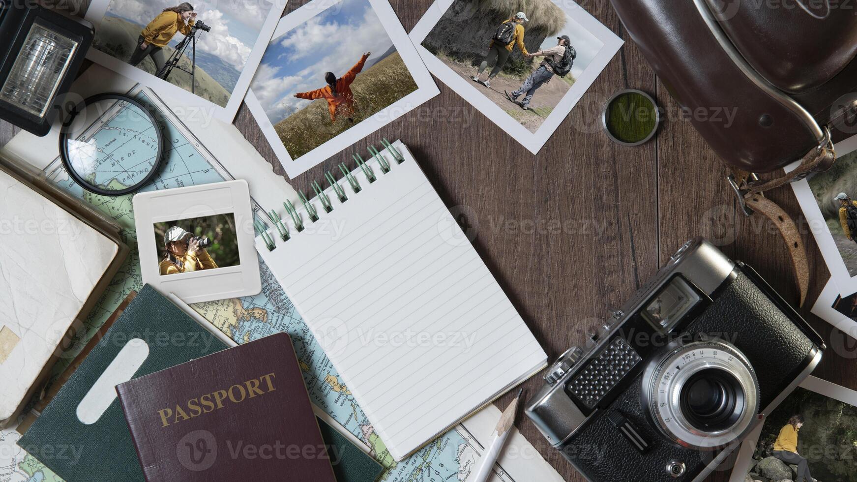 Couple photographs, travel photos, passports, old camera, map and notebook on a dark wooden table photo