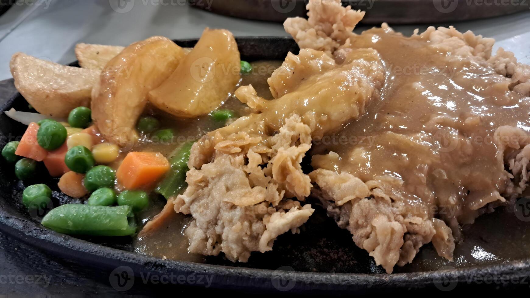 a plate of food with meat, potatoes and vegetables photo