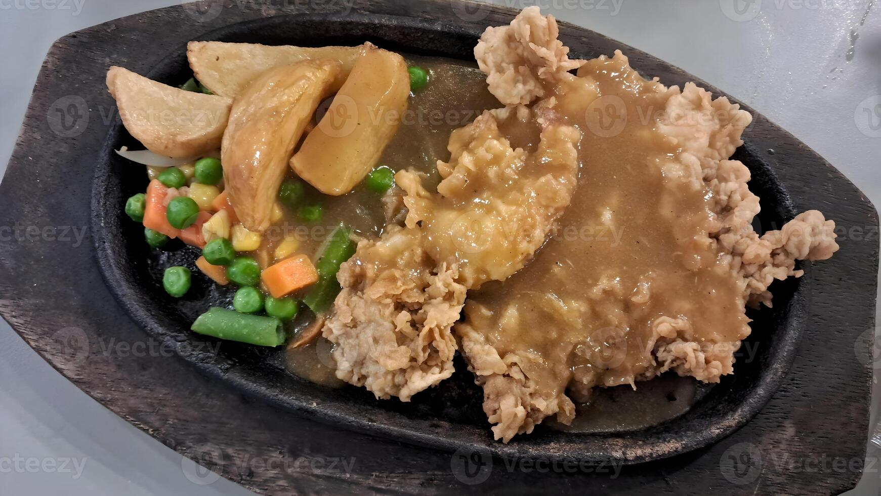 a plate with chicken, vegetables and gravy on it photo