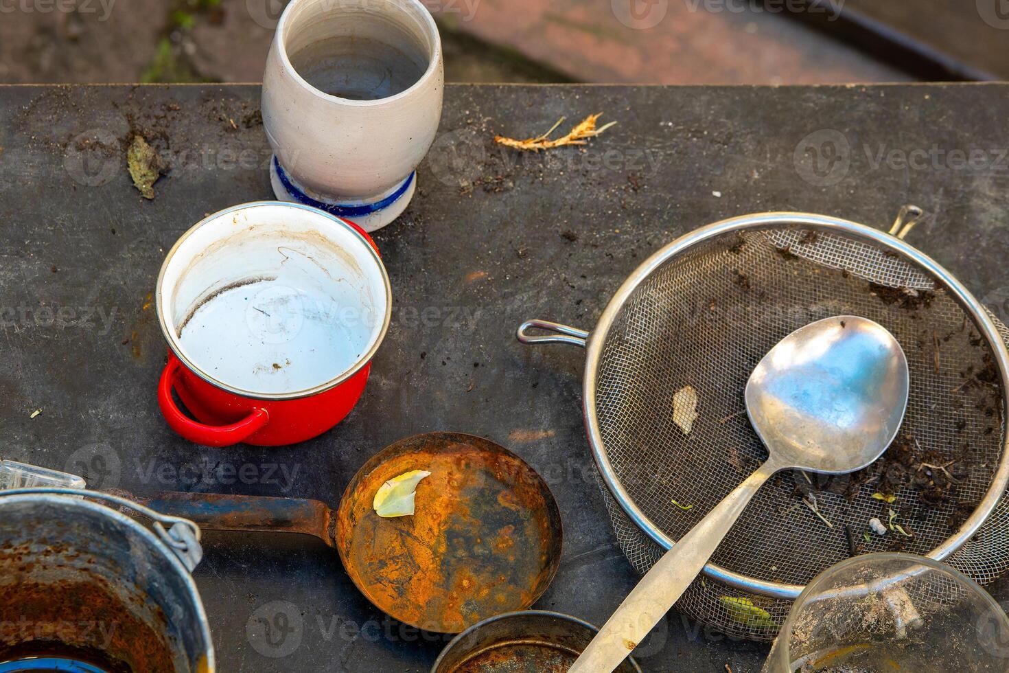 dirty table with a red bowl, a white bowl, a spoon, and a spatula photo