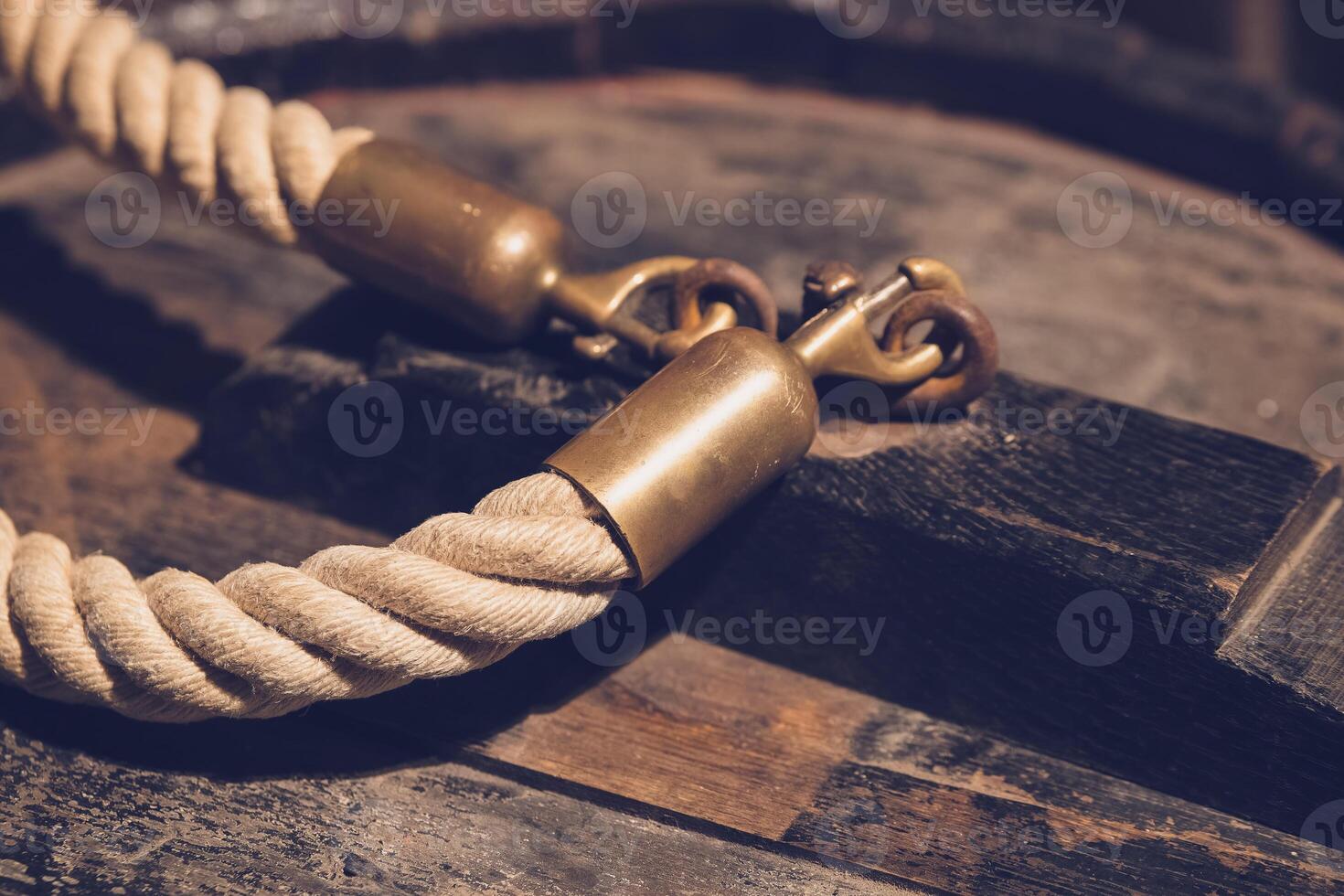 rope with a gold clasp is laying on a wooden surface photo