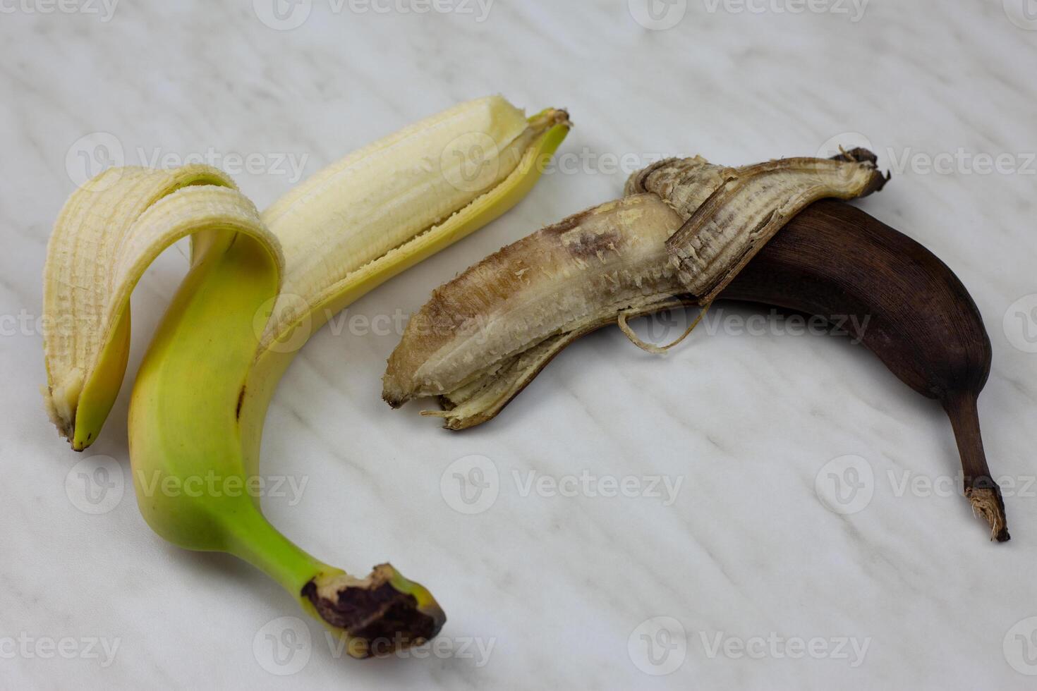 Fresh and spoiled banana on white table photo